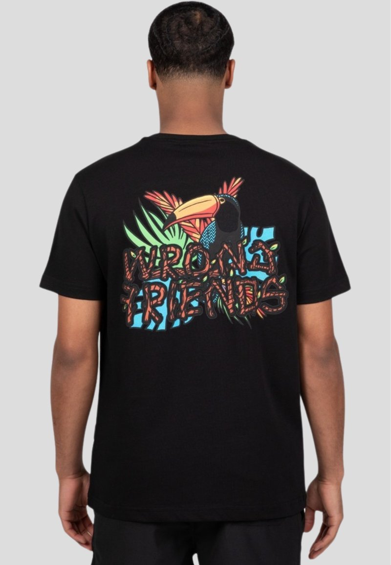 Sort bomulds t-shirt med et farverigt tucan- og tropisk blad grafik på ryggen, samt teksten "WRONG FRIENDS" i fed skrift.