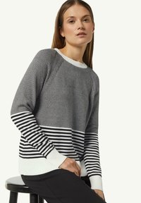 Schwarz-weiß gestreifter Pullover mit einem gerippten weißen Kragen und Bündchen. Verfügt über ein horizontal gestreiftes Muster im unteren Bereich.