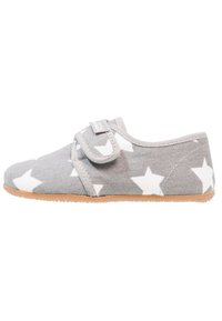 Chaussure en tissu gris avec un motif d'étoiles blanches, une bande Velcro, un bout arrondi et une semelle en caoutchouc beige. Design léger et décontracté.