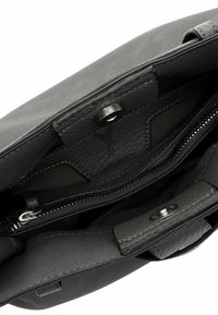 Interior de bolso de cuero negro que muestra un bolsillo con cremallera, cierre de imán y detalles en cuero texturizado.