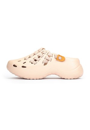 Sabots beige clair avec un design tissé, dotés de ventilations latérales, d'une finition texturée et d'une boucle orange contrastante.