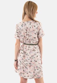 Vestido ligero de manga corta en un patrón floral pastel con cintura ajustada y falda en capas. Hecho de una tela suave y fluida.