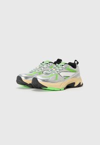 Sneaker in rete argento con dettagli verdi, particolari neri e suola chunky beige. Presentano punta arrotondata e design con lacci, dotati di linguetta.