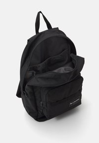 Czarny plecak wykonany z trwałego materiału, z dużą komorą główną, przednią kieszenią na zamek i naszywką z logo. W zestawie regulowane szelki.