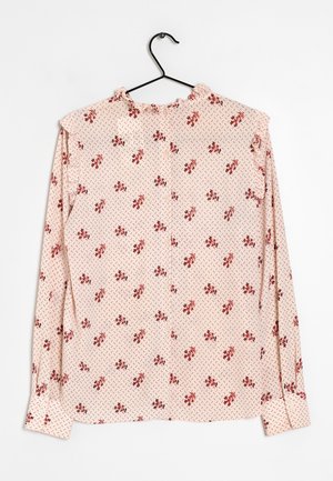 Langærmet skjorte med knapper i lyserød stof med rødt blomsterprint og kontrasterende diamantmønster. Har en flæsekrave og flæser ved ærmerne.