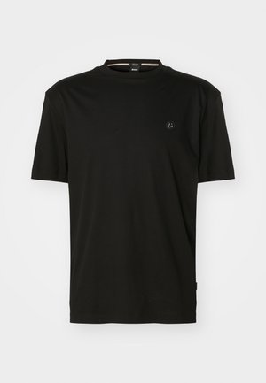 T-shirt preta feita de algodão suave, com decote redondo e mangas curtas. Pequeno logo no lado esquerdo do peito e design minimalista.