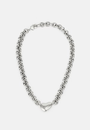 Stříbrný řetízek s náhrdelníkem, který se skládá z propojených kulatých oček a leštěného srdcového akcentu uprostřed. Zahrnuje bezpečné zapínání.