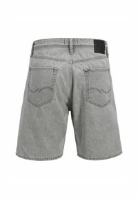 Shorts en denim gris au fit décontracté, avec deux poches arrière avec des coutures courbes, et une étiquette noire au niveau de la taille.