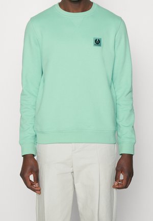 Mint green sweatshirt with crew neck, ribbed cuffs, and hem. Features a small black logo patch on the chest. Smooth, cotton blend texture.