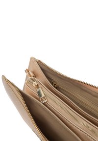 Clutch beige con zip, dotato di molteplici scomparti, hardware in tonalità dorata e tessuto texture. Presenta due tasche interne e una fodera morbida.