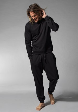 Schwarzes Sweatshirt und passende Jogginghose aus weichem Stoff, mit lockerer Passform, gerippten Bündchen und elastischem Bund.