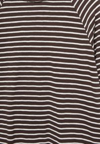 Brown and white striped fabric with a soft texture, featuring horizontal lines of equal width. Close-up on a shirt's design details.