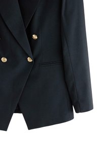 Dobbeltradet navy blazer lavet af tekstureret stof med guldbeslag, en enkelt brystlomme og strukturerede skuldre.