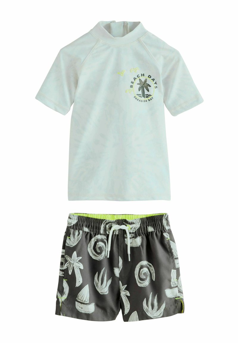 Rash guard a maniche corte di colore azzurro chiaro con grafica "BEACH DAYS", abbinato a shorts da bagno antracite con motivi tropicali bianchi e accenti neon.