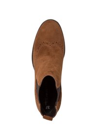 Botín de ante marrón hasta el tobillo con detalle de brogue, paneles laterales elásticos y una asa en el talón, mostrado desde una vista superior.