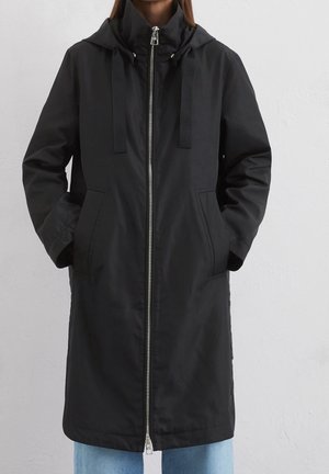 Cappotto impermeabile nero con zip frontale, cappuccio, cordini regolabili, tasche frontali e una texture liscia. Design di lunghezza intermedia.