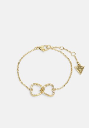 Bracciale in metallo dorato con simbolo dell'infinito decorato con strass, completato da una delicata catena e un piccolo ciondolo triangolare.