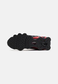Schwarze und rote Sport Schuhsohle aus Gummi, mit strukturierten Profilmustern für Grip und Haltbarkeit, entworfen für Leistung.