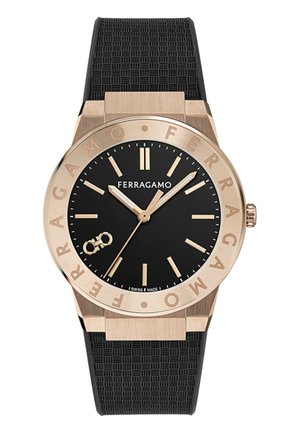 Zegarek Ferragamo na nadgarstek z czarną tarczą, złotymi znacznikami godzin, wskazówkami, bezelem z wygrawerowaną nazwą marki oraz teksturowanym czarnym paskiem z gumy.