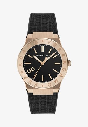 Schwarze Ferragamo-Armbanduhr mit Zifferblatt, goldfarbenen Stundenmarkierungen, Zeigern, Lünette mit eingraviertem Markennamen und strukturiertem schwarzem Gummiband.