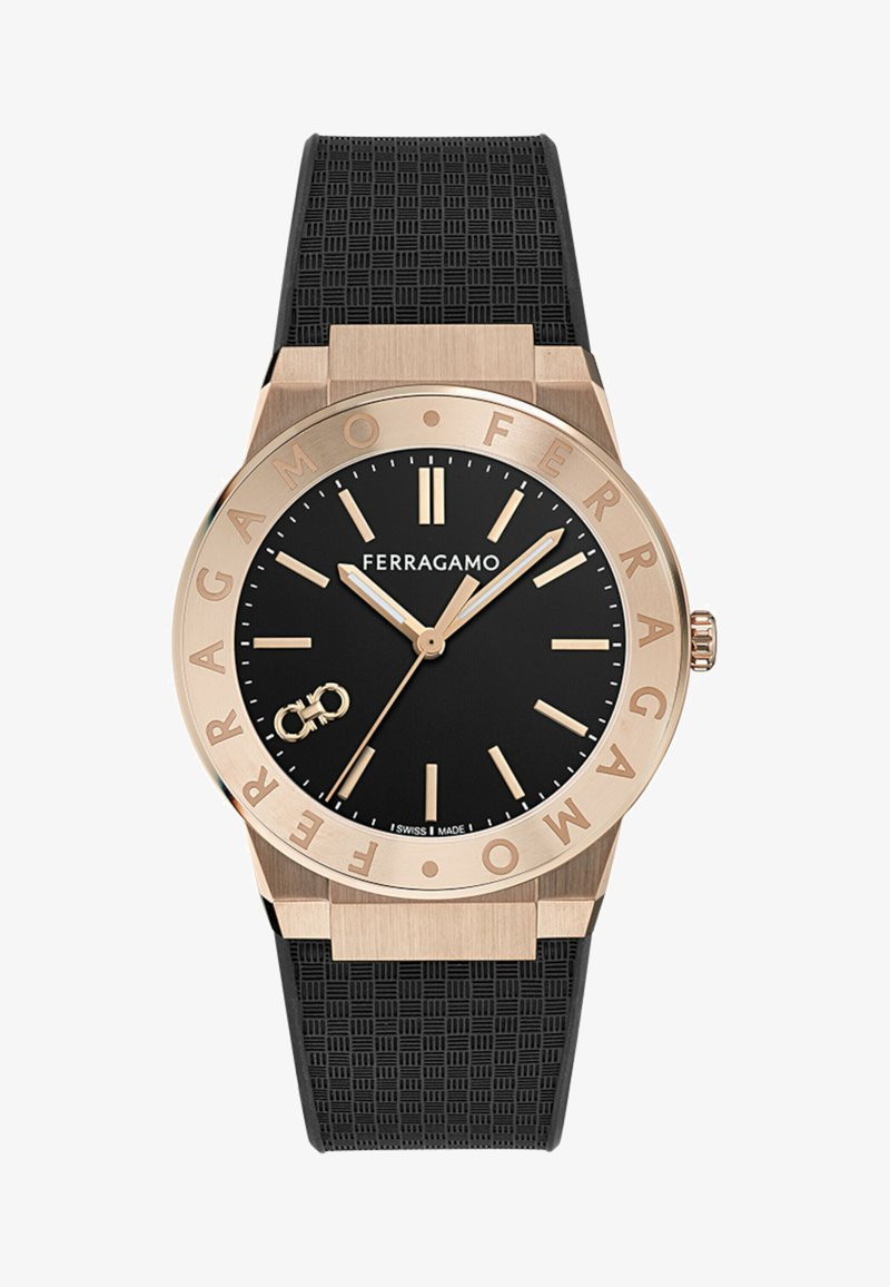 Čierne ciferník hodinky Ferragamo s hodinovými značkami a ručičkami v zlatej farbe, luneta s rytým názvom značky a čierny textúrovaný gumový remienok.