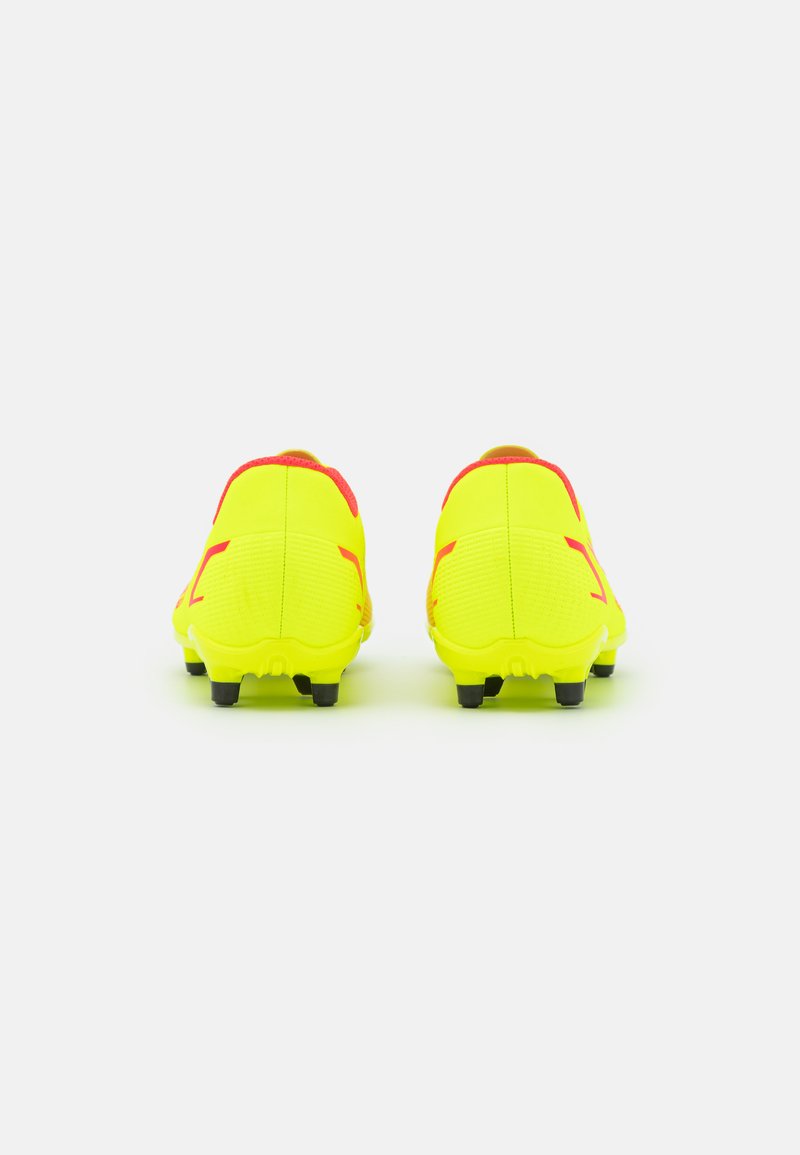 Des crampons de football en jaune vif avec des accents rouges, présentant une surface texturée et une forme incurvée. Des crampons noirs offrent de l'adhérence.