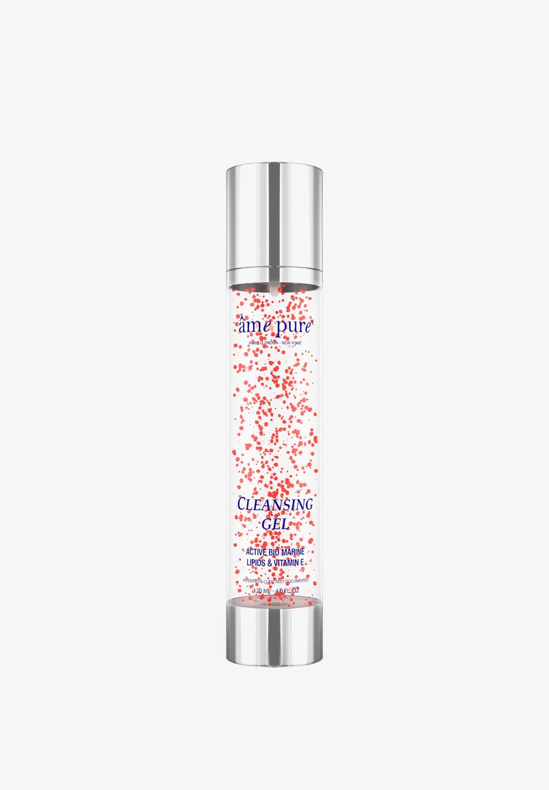 Klar cylinderformet flaske med en sølvhætte. Gelen indeholder røde partikler og er mærket "Cleansing Gel" i blå tekst, med ingrediensdetaljer nedenfor.
