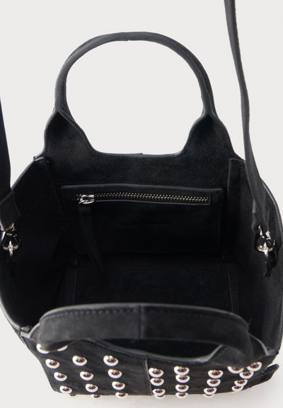 Μαύρη τσάντα χειρός από σουέτ με ασημένιες τρουκς, πάνω λαβή, αφαιρούμενο ιμάντα ώμου και εσωτερική τσέπη με φερμουάρ, φαίνεται ανοιχτή από επάνω.