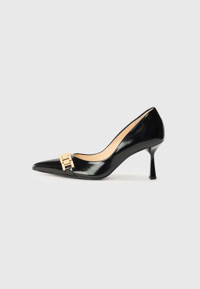 Black patent leather high-heeled pumps with a pointed toe and gold-tone hardware accent at the front. Textured finish and slender heel.