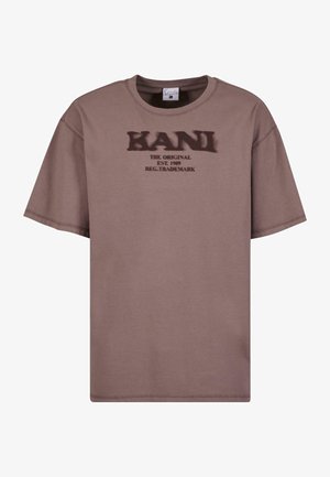 Brown cotton t-shirt with short sleeves, round neckline, and graphic print including "KANI THE ORIGINAL EST. 1989" in dark text.