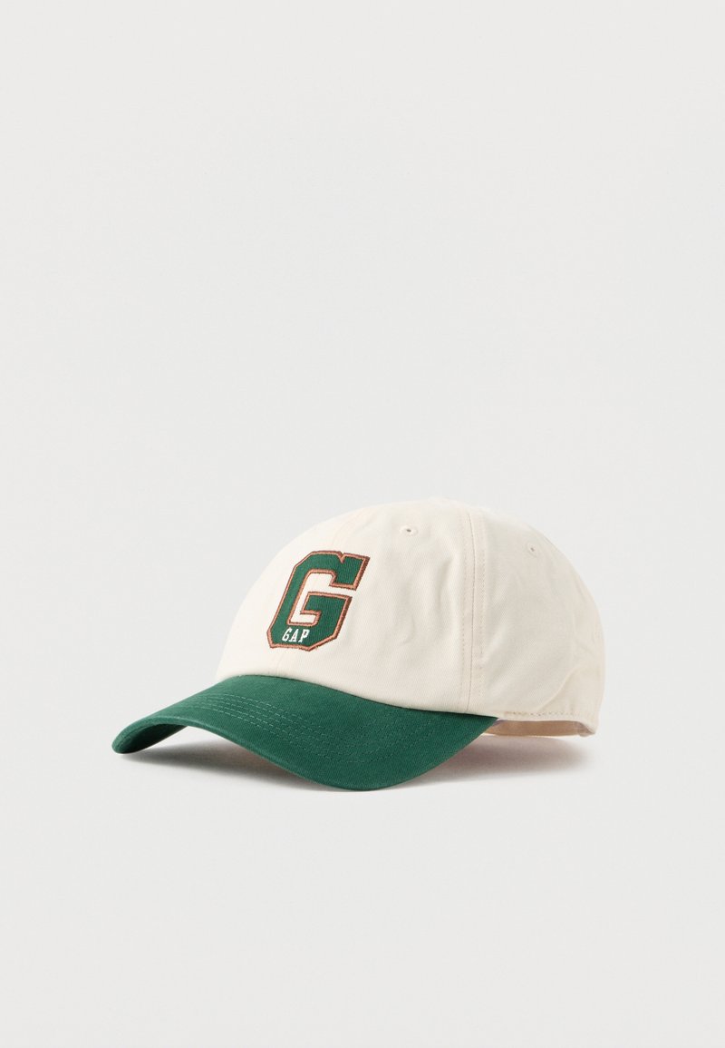 Caps med kremfarget krone, grønn visir og "GAP"-logo i grønn og brun broderi foran. Laget av bomull, uformell design.