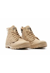 Bottines montantes beiges en tissu résistant, avec une texture extérieure, des accents en relief, des lacets et une fermeture éclair sur le côté pour un accès facile.