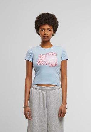 Light blue crop top made from soft fabric featuring a graphic in pink text that reads "CAN I GIVE YOU A KISS" alongside pink lips and bubble graphic.