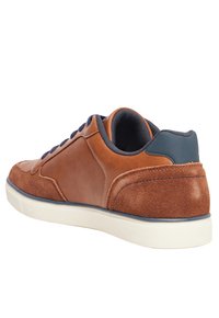 Sneaker in pelle marrone con pannello in suede, dettagli in navy e suola in gomma bianca. Presenta una forma arrotondata e un tallone testurizzato per una migliore aderenza.