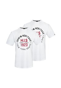 Bílá bavlněná trička s kulatým grafickým potiskem v černé a červené barvě. Text obsahuje "DENIM HERITAGE," "H.I.S," a "1923." Krátké rukávy.