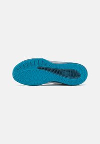 Suela de zapato deportivo con una parte inferior de goma azul texturizada y un patrón geométrico para tracción y durabilidad. El diseño es elegante y aerodinámico.