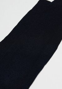 Marineblå strikkede sokker med en glat tekstur, der har et klassisk design og jævn syning på stoffet.