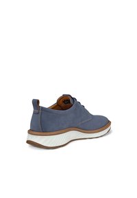 Scarpa blu in suede con punta rotonda e suola in gomma bianca testurizzata. Presenta dettagli cuciti e un accento in pelle marrone nel tallone.