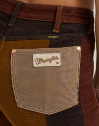 Corduroy broek met een multicolore patchworkontwerp in bruin, goud en tan. Inclusief een merk-kruipzak en opvallende stiksels.