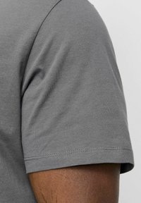Grau Kurzarm-T-Shirt mit weicher Textur, Rundhalsausschnitt und sichtbarer Naht an den Ärmeln und dem Saum.