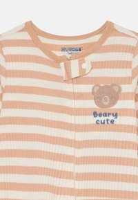 Body de bebé a rayas en melocotón y crema, con un parche de oso y el texto "Beary cute", con un cierre a presión en el cuello. Tela suave.