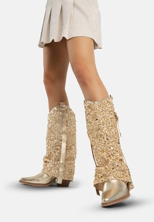 Gouden met pailletten bezette cowboylaarzen met een spitse neus, gestructureerde afwerking en decoratieve accenten, met een lage blokhak en zijstrikjes.