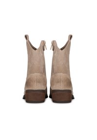 Botas de tobillo de ante beige con forma cónica, costuras decorativas y cremalleras laterales dobles; tacón de madera apilada; textura suave.