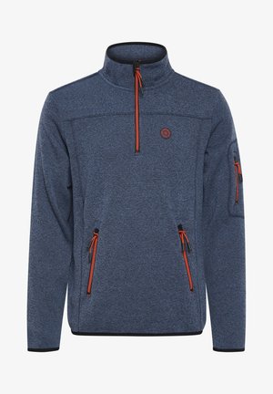 Tumši zila flīsa džemperis ar augstu apkakli, oranžiem rāvējslēdzējiem, divām sānu kabatām un kabatu piedurknē. Tekstūrēts audums un melni akcenti.