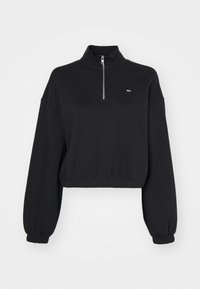 Felpa nera cropped con colletto alto, zip a metà davanti e polsini elasticizzati. Tessuto liscio con un piccolo logo sul petto.