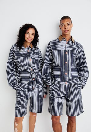 Striped jacket and shorts set in navy and white with contrasting brown collar and orange buttons, featuring pockets and a relaxed fit.