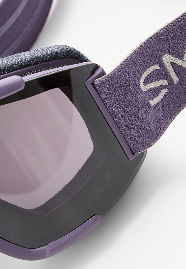 Lila Skibrille mit einem schwarzen Rahmen, dunkler getönter Linse und verstellbarem Riemen mit strukturiertem Design. Weiche Polsterung für Komfort.