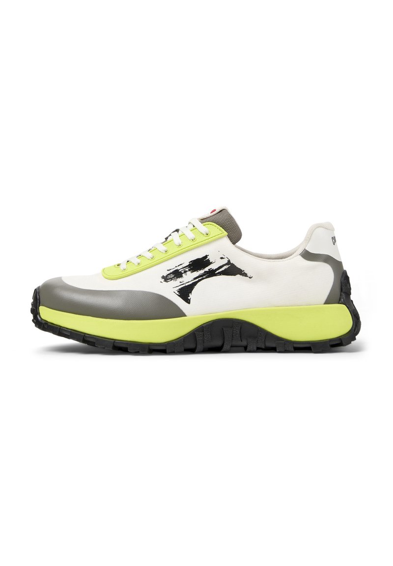 Sneakers feature a white canvas upper, gray rubber accents, neon green laces, a prominent logo, and a textured black sole for grip.