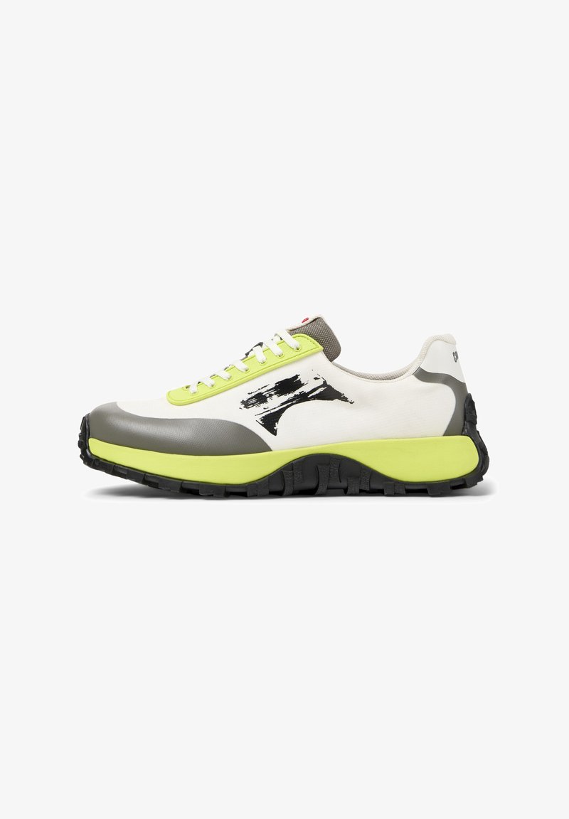 Les baskets présentent une tige en toile blanche, des accents en caoutchouc gris, des lacets vert fluo, un logo bien visible et une semelle noire texturée pour une meilleure adhérence.
