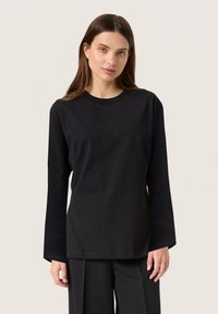 T-shirt nero a maniche lunghe realizzato in cotone, caratterizzato da un collo rotondo e una vestibilità comoda, con una texture liscia e senza motivi visibili.